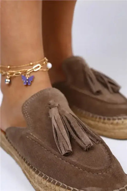 Brown suede espadrille mule with decorative tassels.