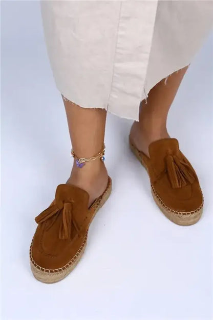 Brown suede espadrille mules with decorative tassels.