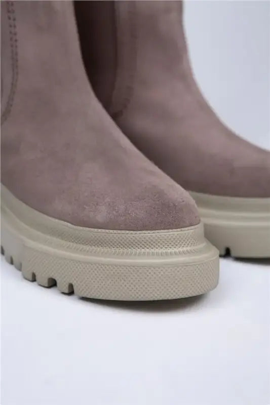 Mauve suede boots with chunky cream-colored platform soles and treaded bottoms.