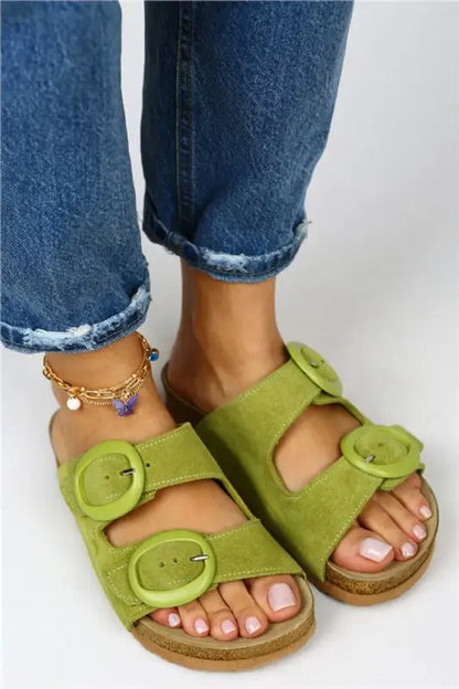 Lime green suede sandals with oversized buckles and a cork footbed.