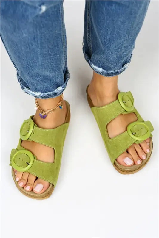 Lime green sandals with decorative buckles and a cork-style sole.