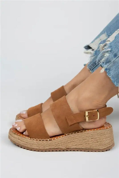 Tan leather platform sandal with espadrille sole and buckle closure.