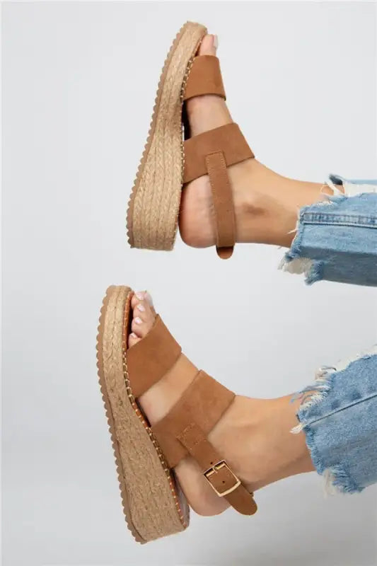 Tan leather platform sandals with buckle straps and an espadrille-style sole.