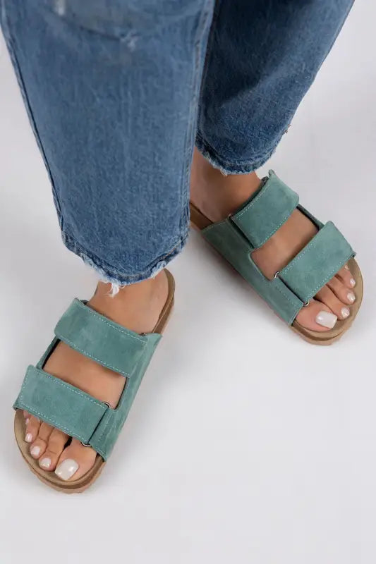 Mint green double-strap sandals with a flat sole.