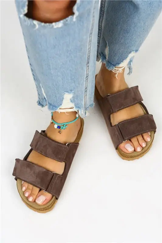 Brown leather double-strap sandals with a cork footbed.