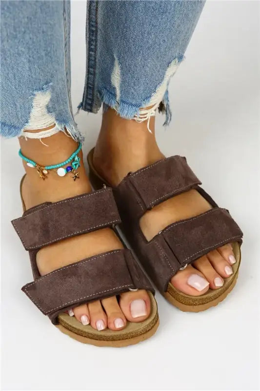 Brown suede double-strap sandals with adjustable velcro closures.