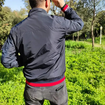 Navy blue windbreaker jacket with red trim.