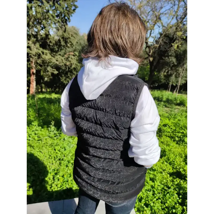 Black quilted vest worn over a white hooded sweatshirt.