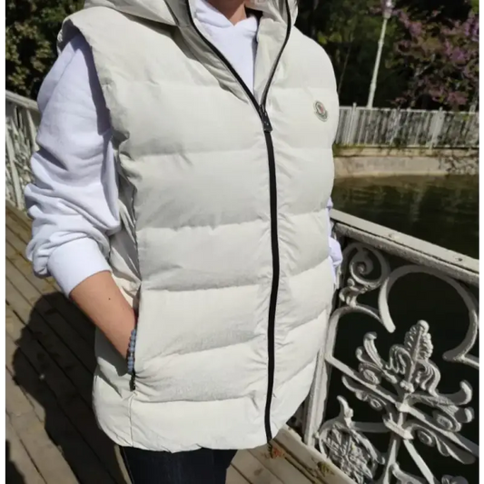 White puffy down vest with black zipper.