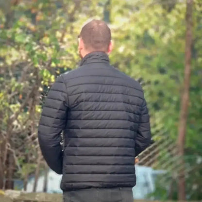 Black quilted puffer jacket worn by someone viewed from behind.