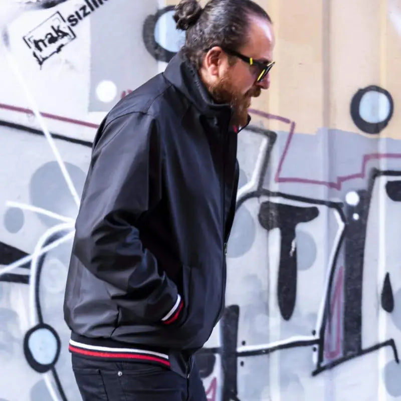 Black bomber jacket with red and white striped trim.