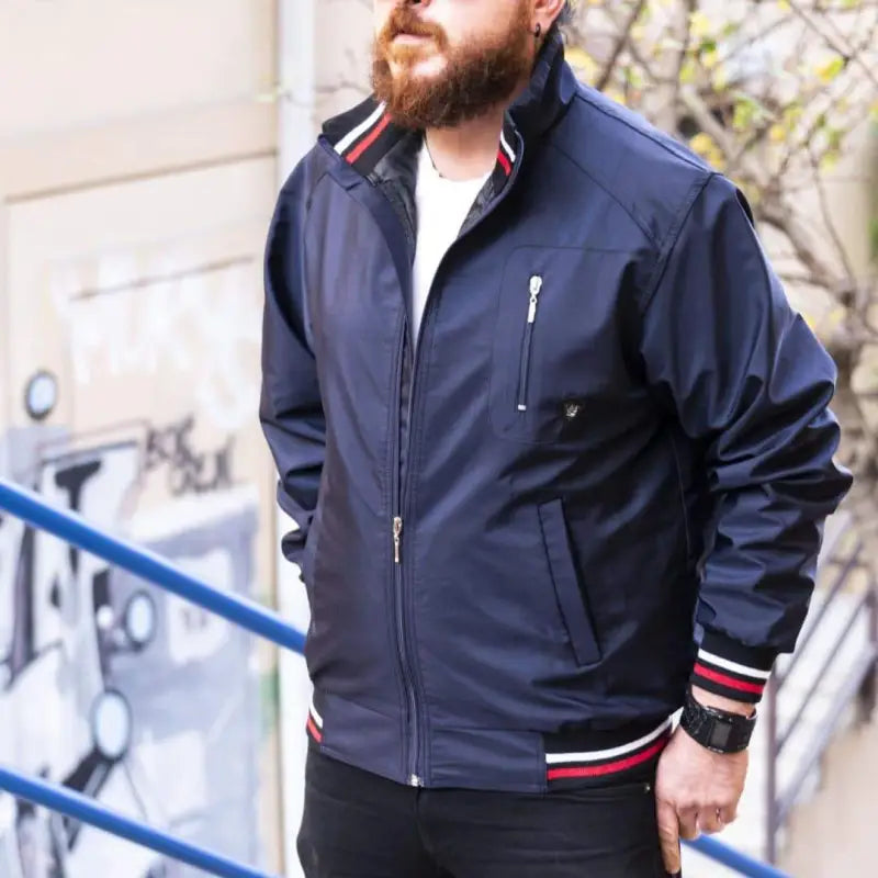 Navy blue bomber jacket with red and white striped ribbing at the cuffs and waist.