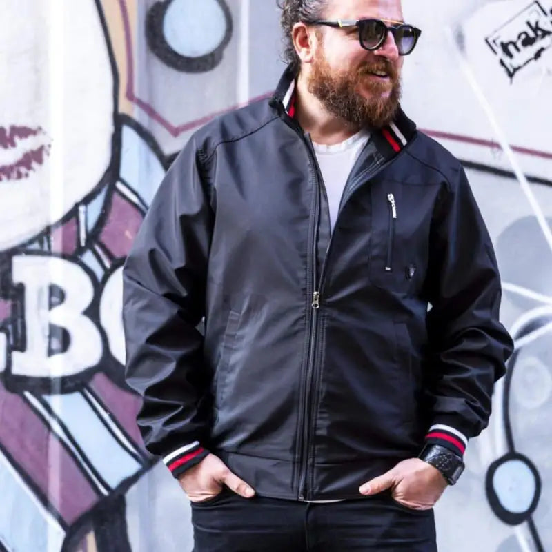 Black zip-up jacket with red and white striped ribbing at the collar and cuffs.