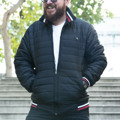 Black quilted bomber jacket with red and white striped trim.