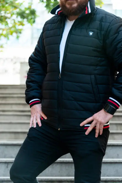 Black quilted puffer jacket with striped ribbed cuffs.