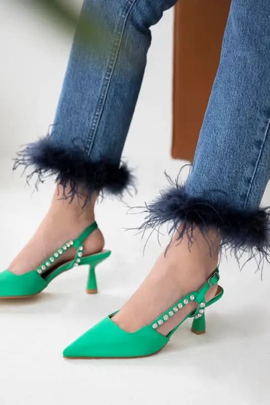 Bright green slingback heels with pearl details and black feather-trimmed jeans.