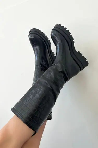 Black leather platform boots with chunky treaded soles.