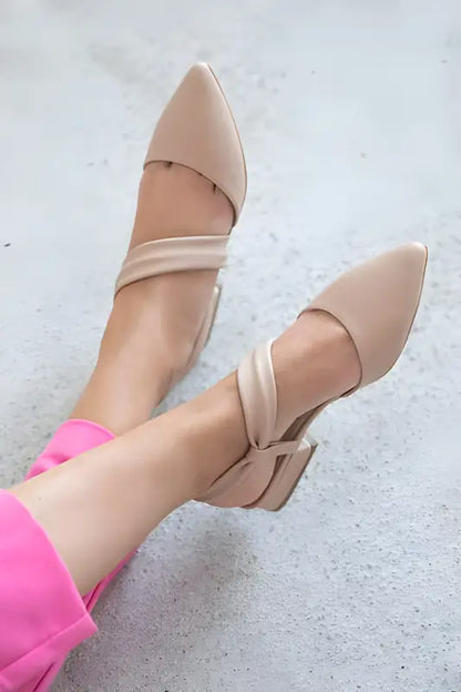 Nude-colored ballet flats with wrapped ankle straps.