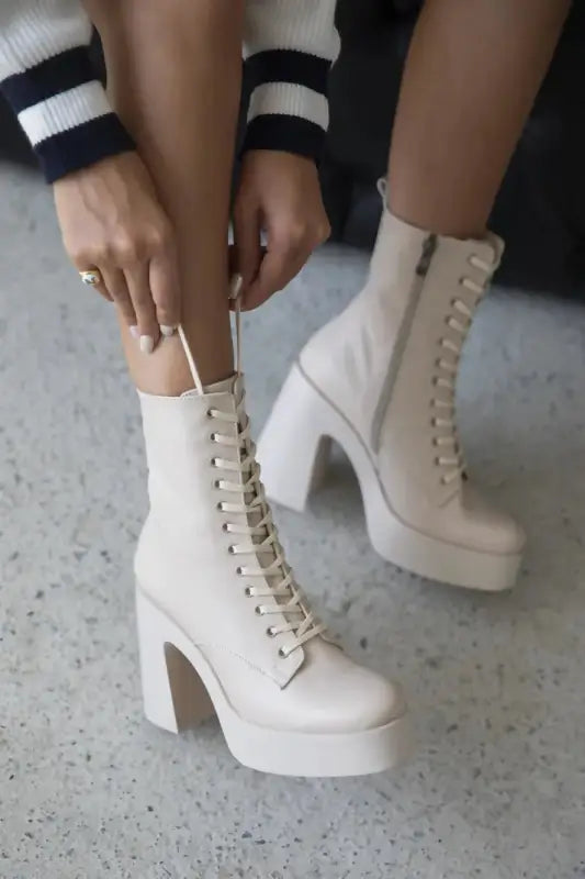 White platform lace-up boots with chunky heels.