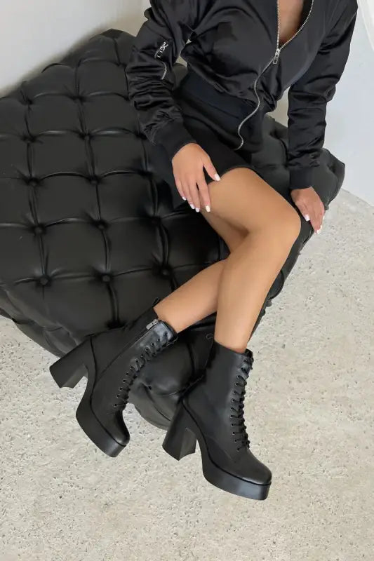 Black platform combat boots with chunky heels and laces.