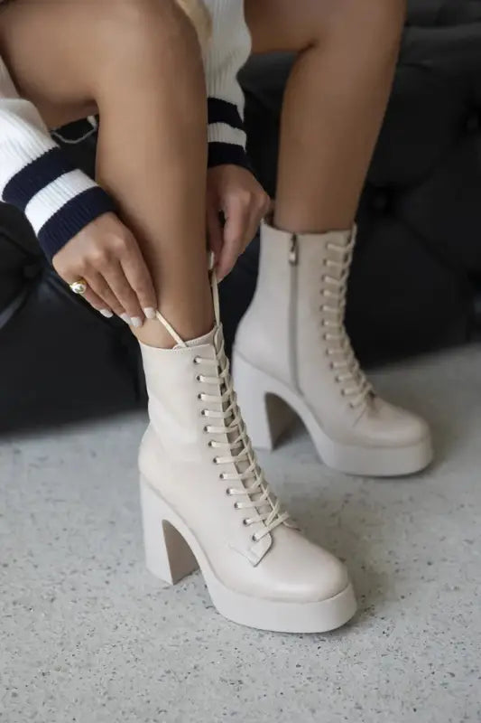 White platform lace-up boots with chunky heels.