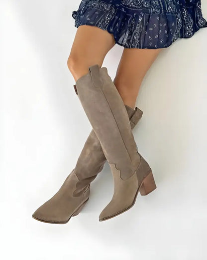 Taupe suede knee-high cowboy boots with a chunky heel.