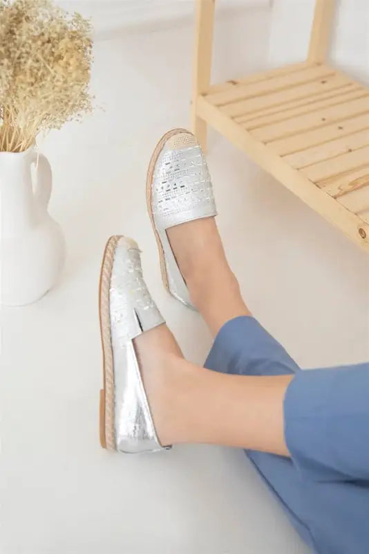 Silver metallic slip-on loafers with perforated leather detailing.