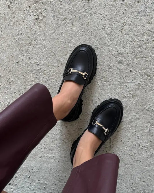 Black leather loafers with metal horsebit hardware.