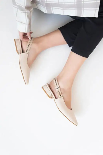 Nude-colored pointed toe flats with delicate pearl strap detailing.