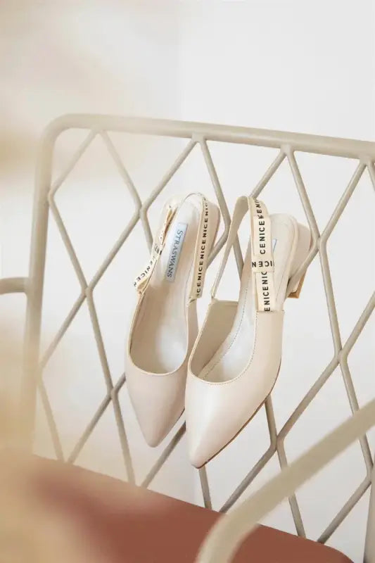 Elegant cream-colored slingback heels with pointed toes.