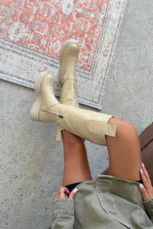 Cream-colored cowboy boots with a square toe design.