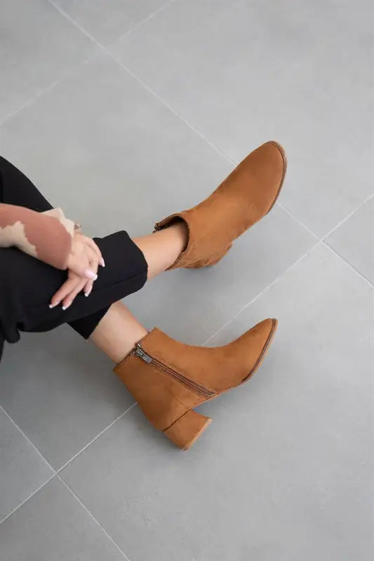 Tan leather ankle boots with a chunky heel and side zipper.