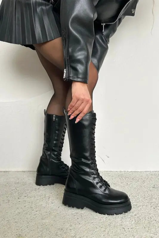 Black leather combat boots with chunky platform soles and lace-up design.