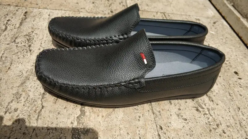 Black leather moccasin-style loafers with visible stitching detail.