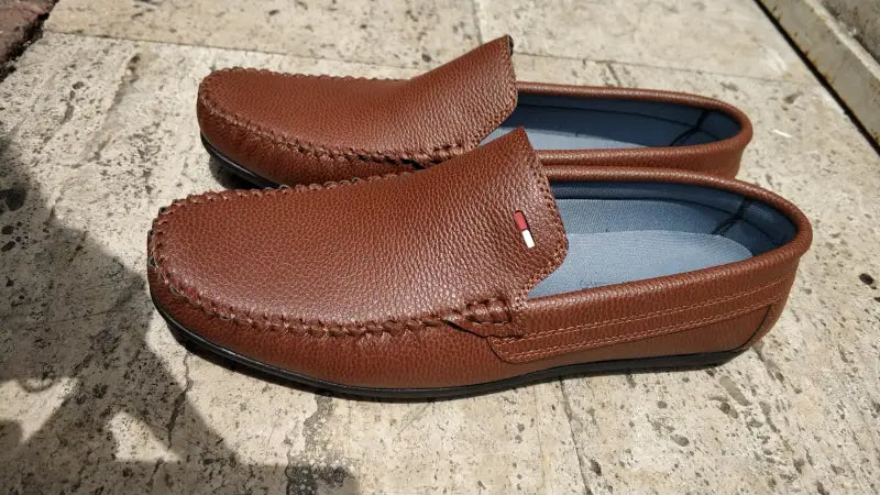 Brown leather loafers with moccasin stitching.