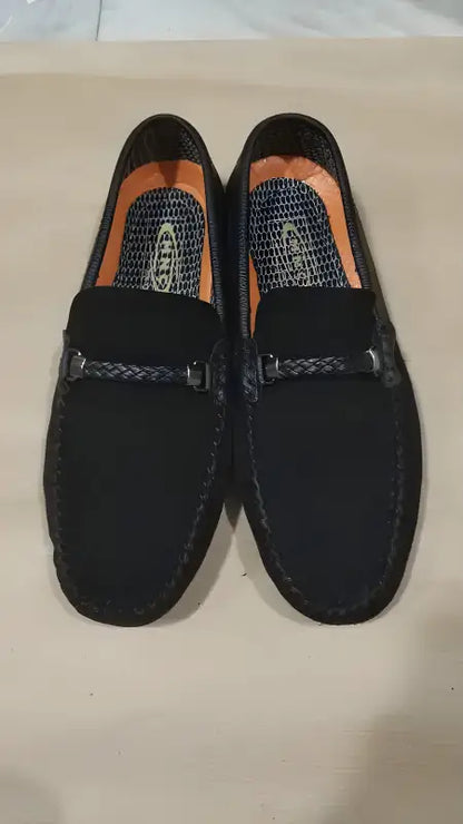 Black suede driving loafers with decorative stitching across the vamp.