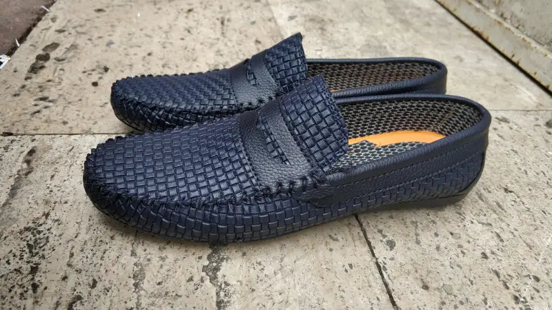 Navy blue woven leather loafers with a slip-on design.