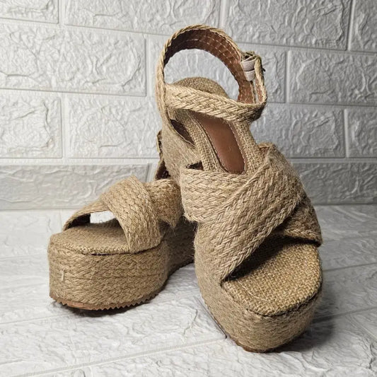 Beige woven platform sandals with criss-cross straps.