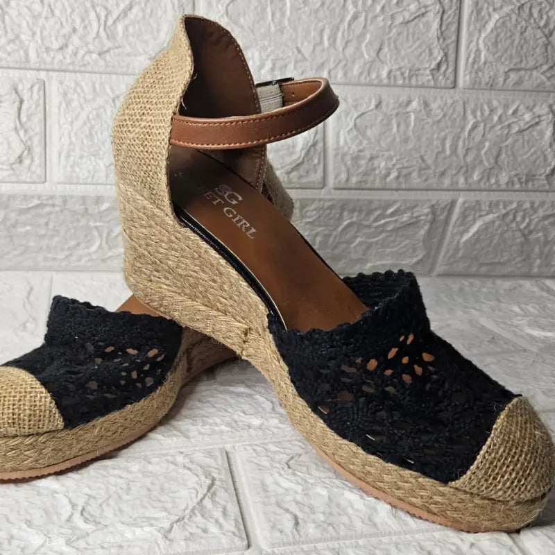 Black lace espadrille wedge sandals with brown ankle straps.