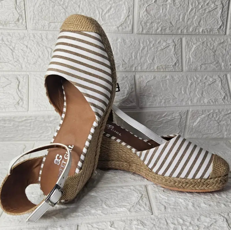 Brown and white striped espadrille sandals with ankle straps.