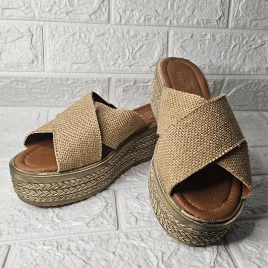 Beige woven platform sandals with crisscross straps.