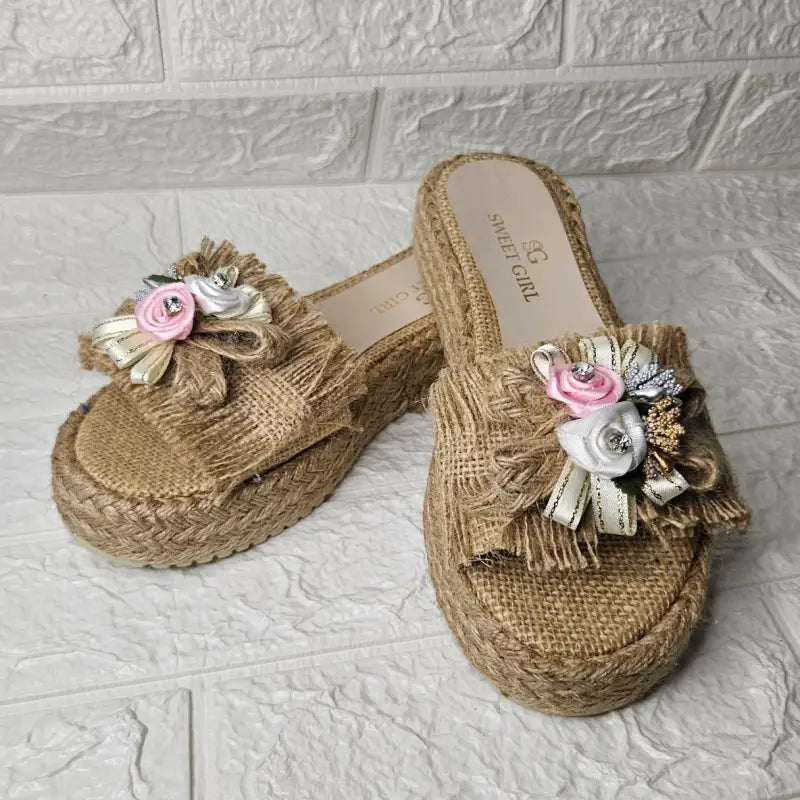 Woven straw platform sandals decorated with fabric flowers and ribbons.