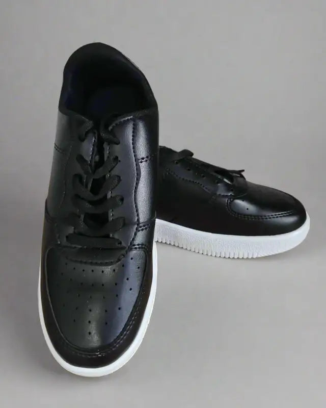 Black leather sneakers with white soles and perforated detailing.