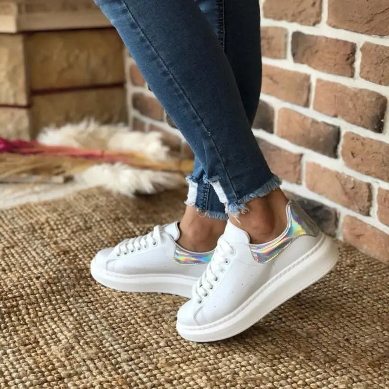 White platform sneakers with iridescent/holographic heel accents.