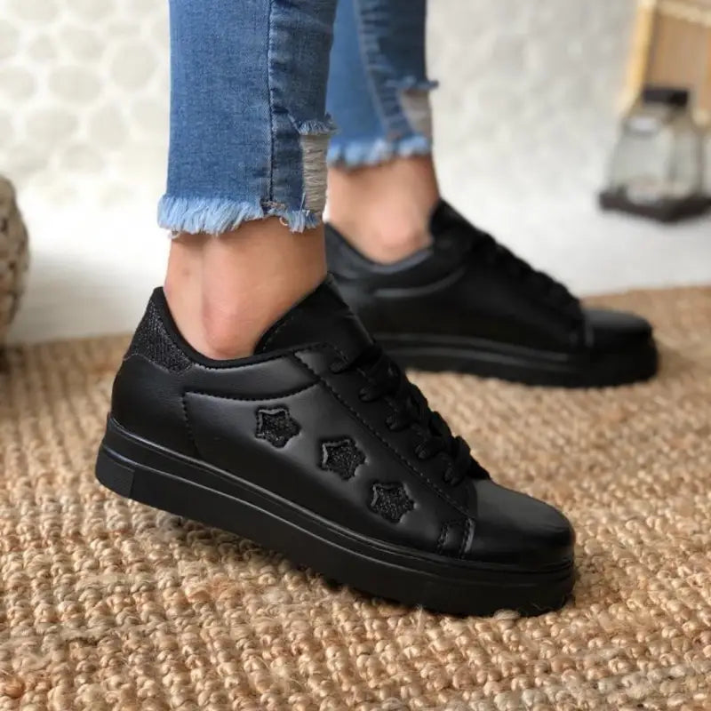 Black leather sneaker with star details and a platform sole.