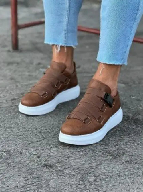 Brown suede monk strap sneakers with white platform soles and double buckle closures.